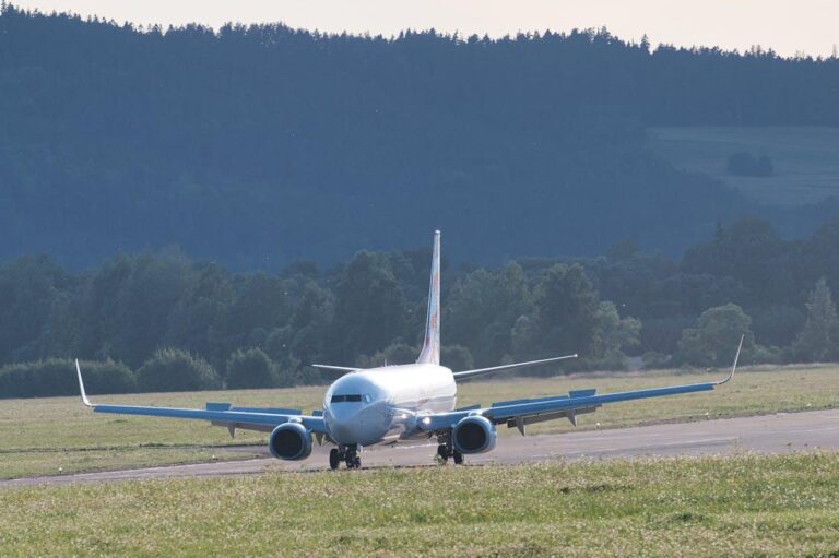 Airplane taxiing on runway at sunset