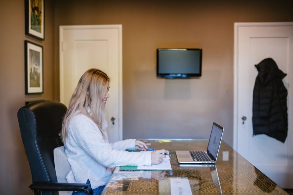 Student using a laptop to complete an online flight course in a home setting