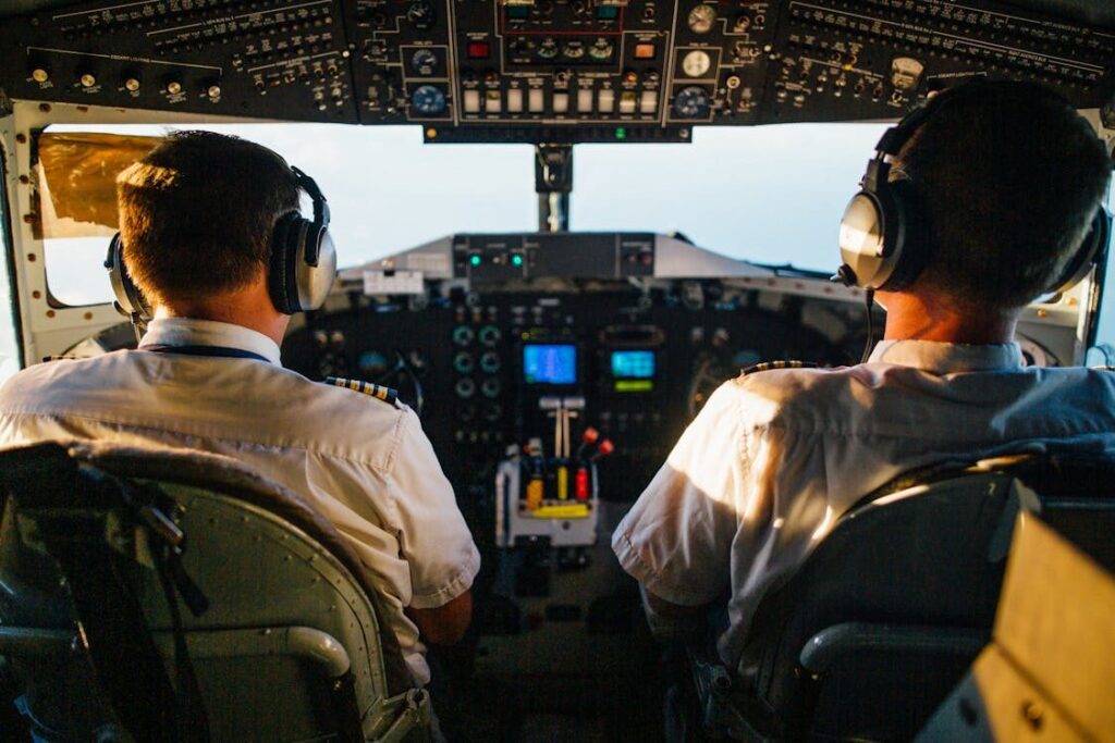 A pilot and an aircraft mechanic discussing technical details beside an airplane.
