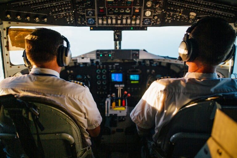 A pilot and an aircraft mechanic discussing technical details beside an airplane.