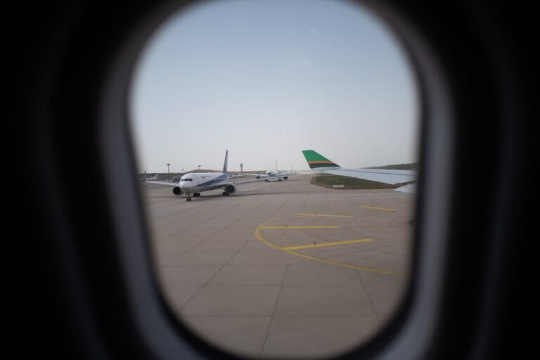 Commercial passenger aircraft lined up at an international airport before departure.